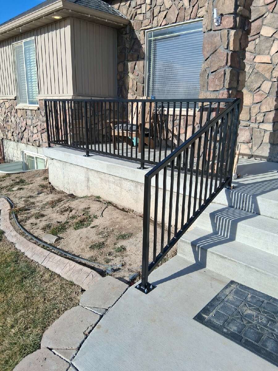 Finished steel handrail on a poured-concrete porch, Rigby