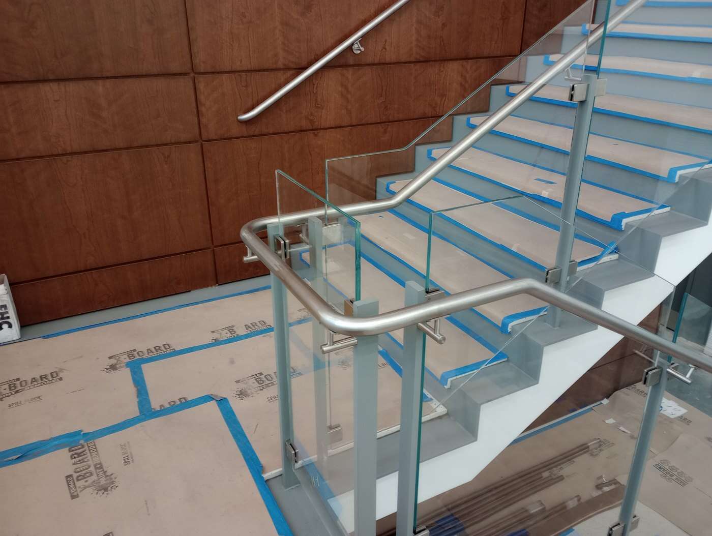 Glass balustrade and stainless steel handrail at a commercial stair landing