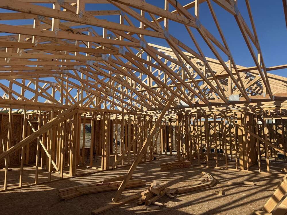 Roof trusses and stud walls framed out against open sky on a Rust Brothers jobsite